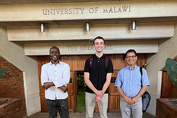 Professor Prakash Adhikari right, wearing blue shirt and glasses) and CMU student Brady Whalen (center, wearing black shirt) visit the University of Malawi.