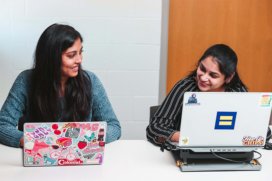 Two girls on laptops in class