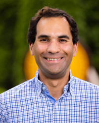 Zachary Johnson wears a blue plaid shirt while posing for a headshot.