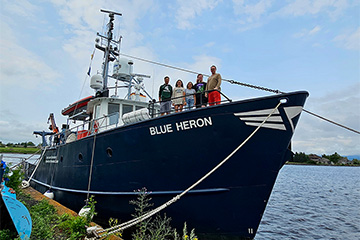 Five members of the research group standing on the deck of the research vessel the Blue Heron