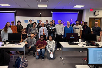 A large group of students posing in a classroom for a picture.