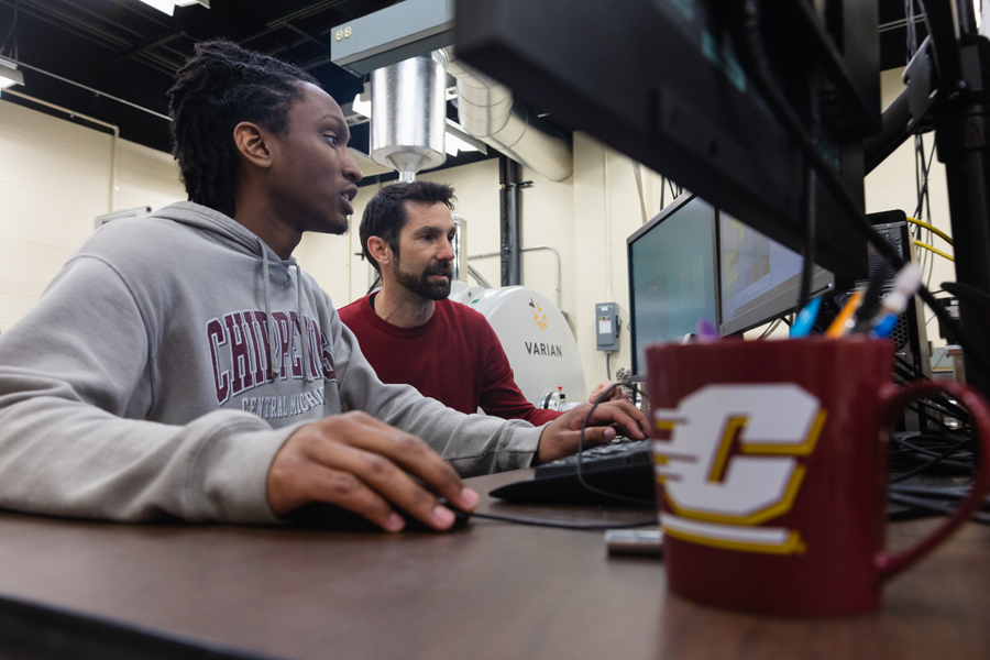 A physics student looking at a computer screen with Matthew Redshaw.