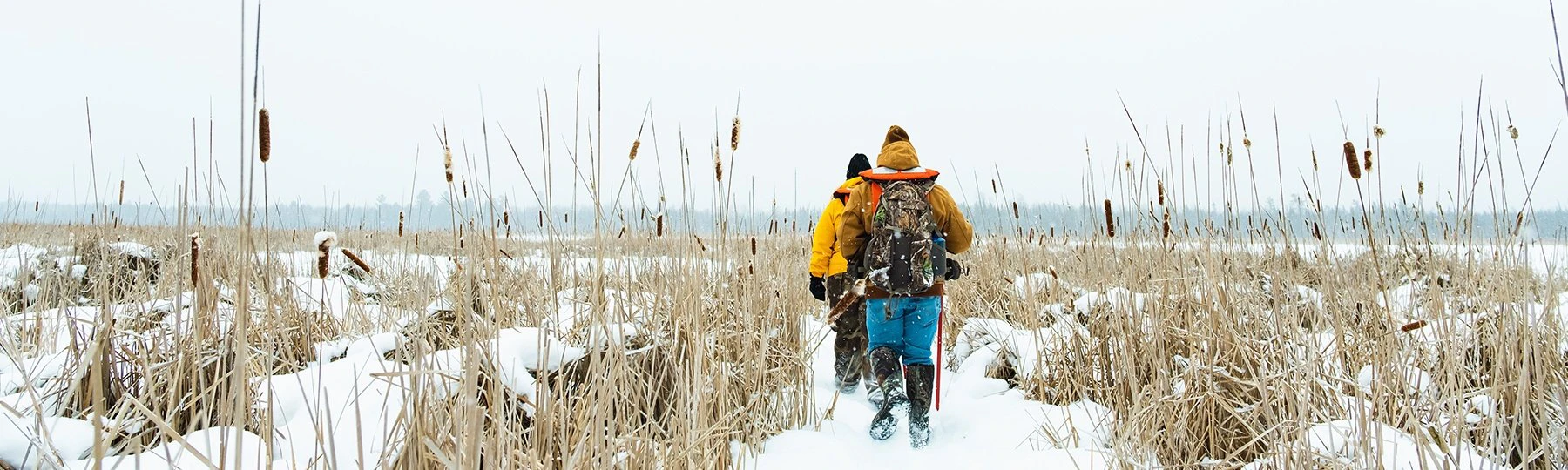 a group of people walking through a snowy field