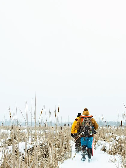 two people walking through a snowy field