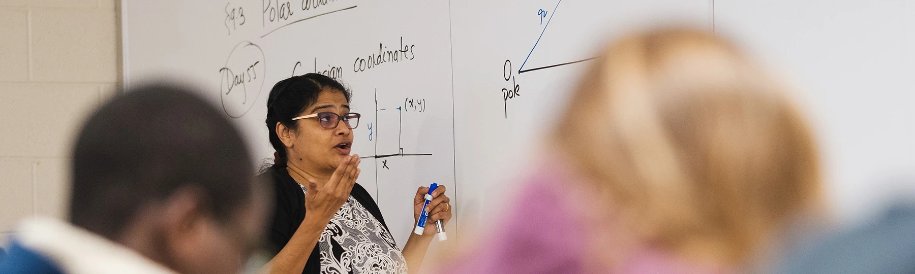 a woman standing in front of a whiteboard