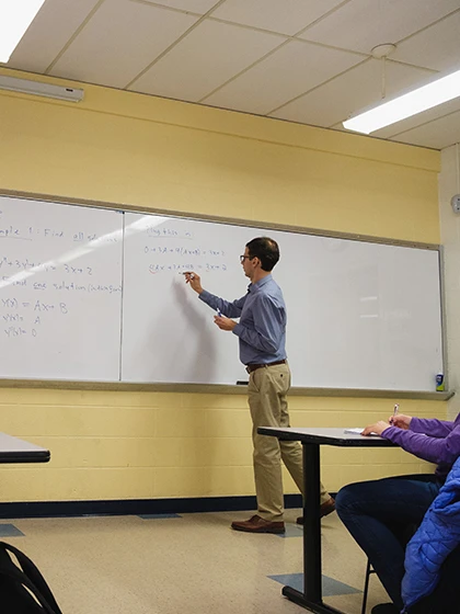 a man writing on a whiteboard