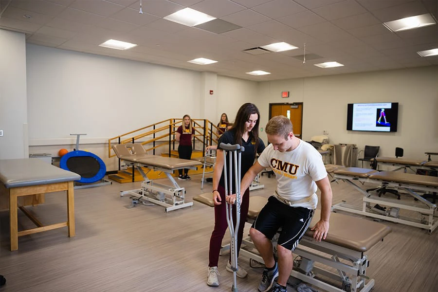 A pre-occupational therapy student works with a patient with crutches.