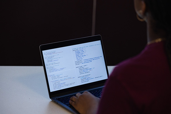 A person typing on a laptop containing different data points.