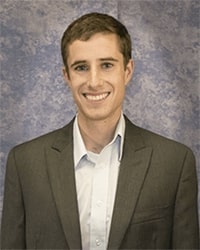 Roderick Lammers wears a jacket and collared shirt while smiling for a headshot.