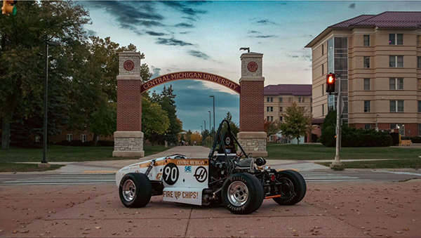 CMU Formula Society of Automotive Engineers card in front of the CMU Arch.