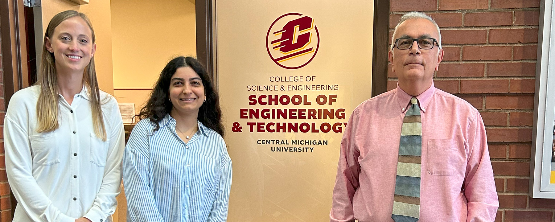 Professor Williams, Yasna Mortezaei, and Goksel Demirer standing in front of the School of Engineering and Technology office.