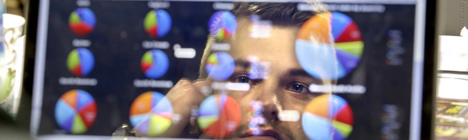 Statistics student examining computer screen full of graphs.