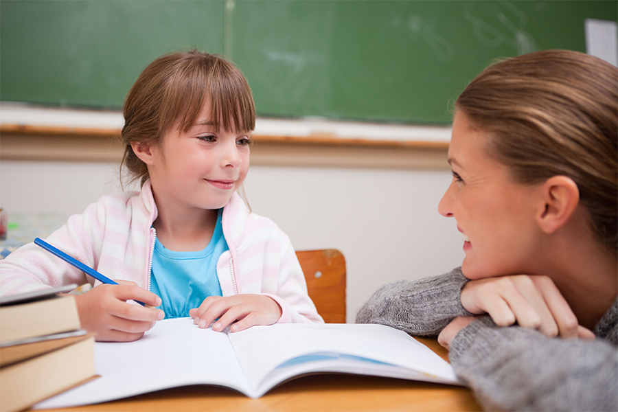 A social studies teacher helping a student in class.