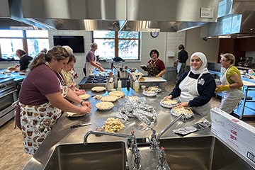 Zonta Club baking apple pies with students in Allen Foundation Culinary Nutrition Center