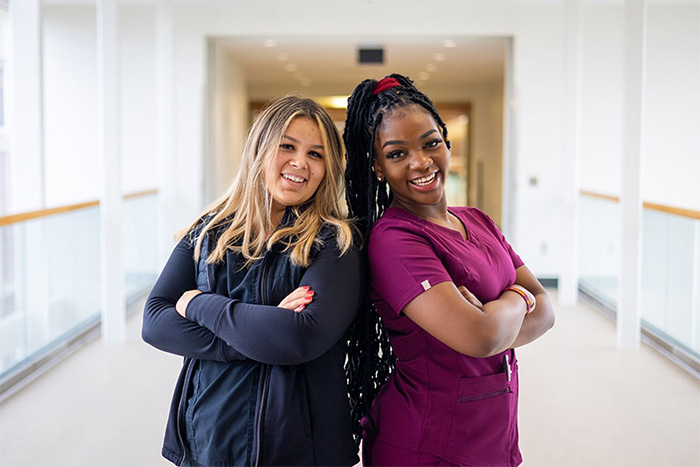 Two nursing students posing in a hallway