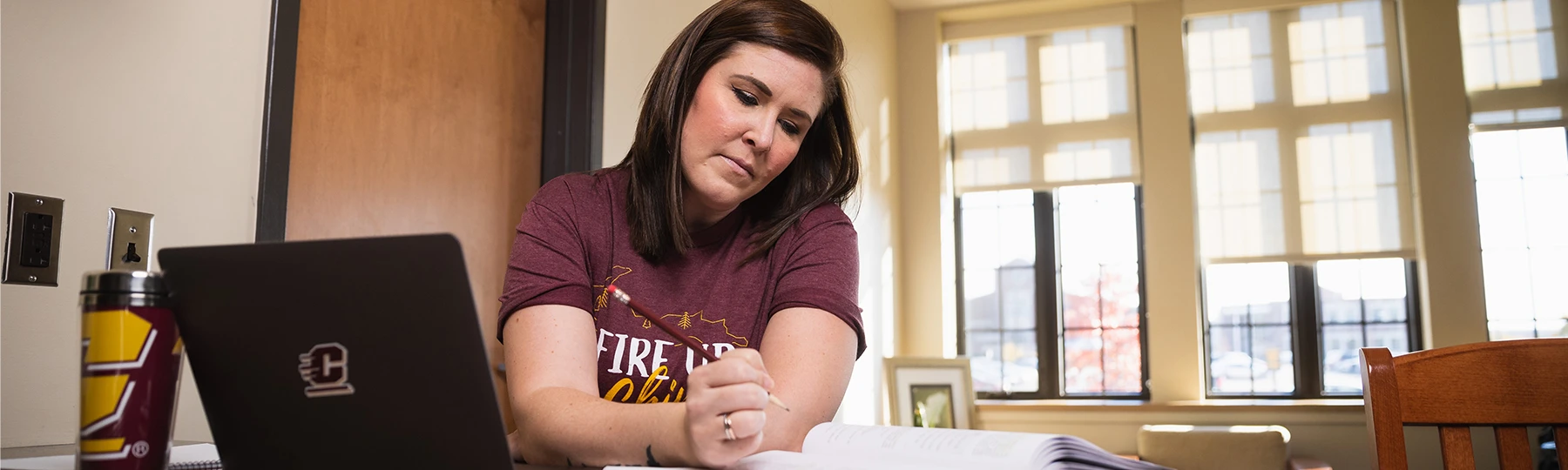 A nutrition and dietetics master's student works through online coursework at her kitchen island.