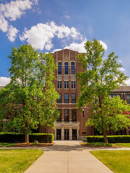 Straight-on view of Warriner Hall on a bright summer day.