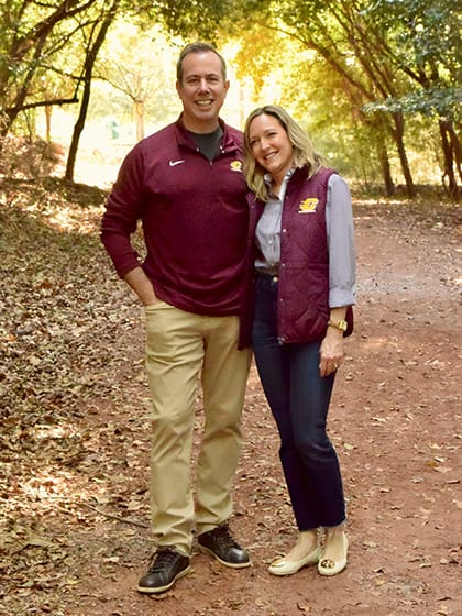 President-Elect Neil MacKinnon and his wife Leanne wear Central Michigan University gear while posing on a nature trail.