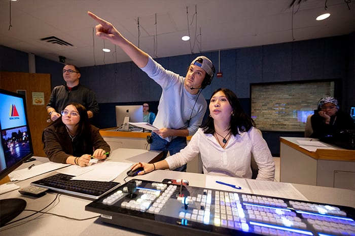 Students and an advisor work in the control room of News Central.