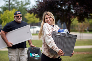 A female student and her father carrying things to move in to her dorm.