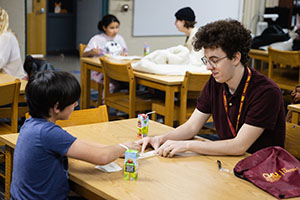 Male student teacher works with young boy to determine his reading level.