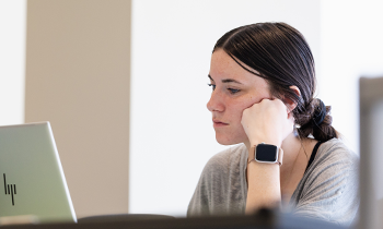 A student looking down at her laptop.