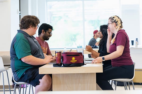 A group of students sit at a table in Charles V. Park Library.