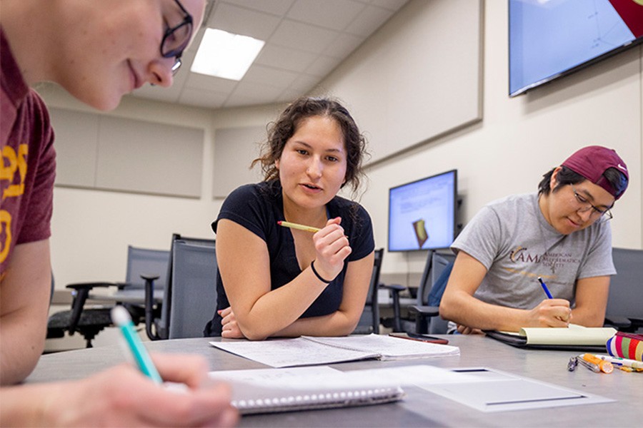 Three math majors collaborate on a problem in an active learning classroom.