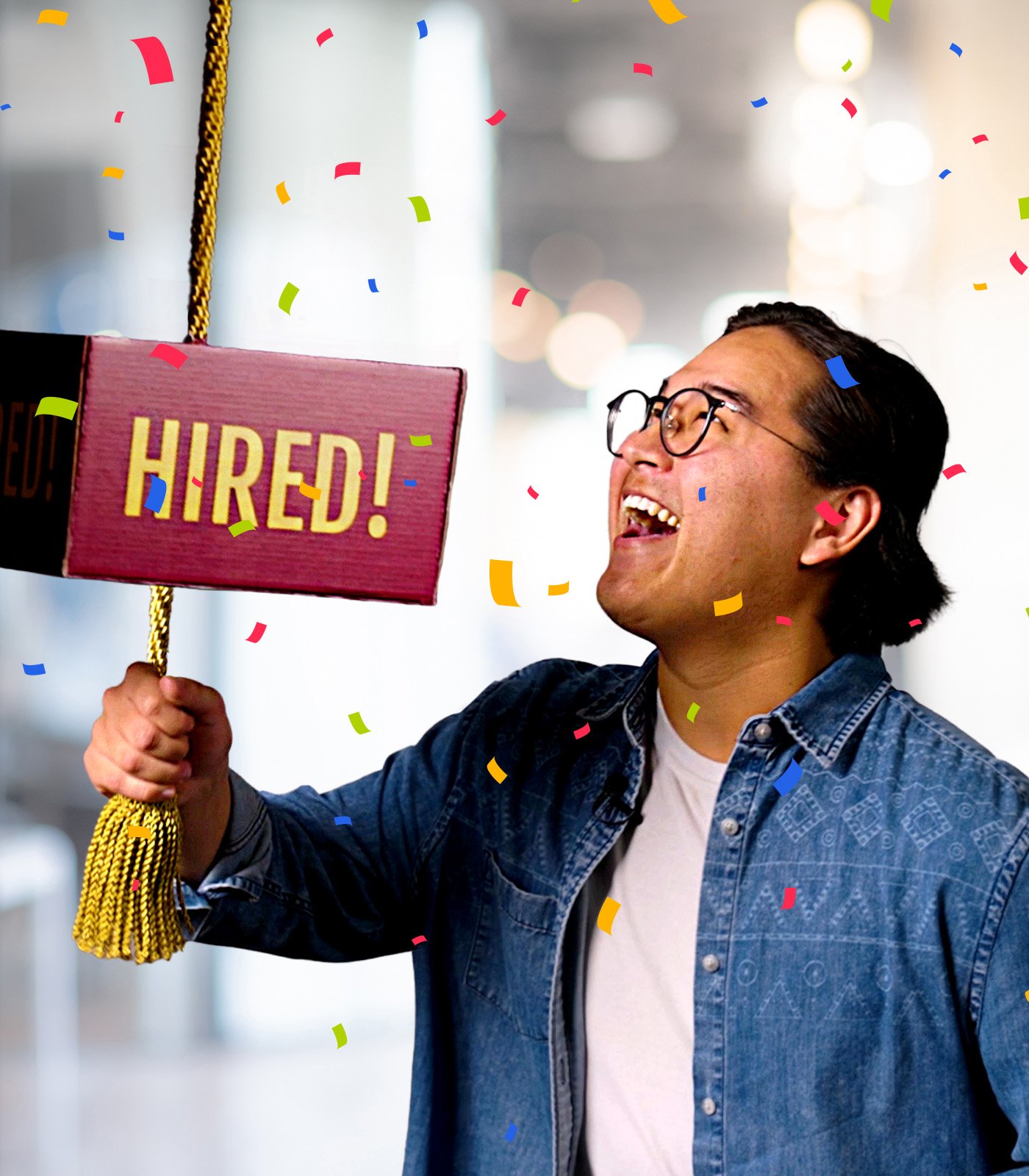 A man pulls on a gold cord connected to a box that reads "HIRED!"