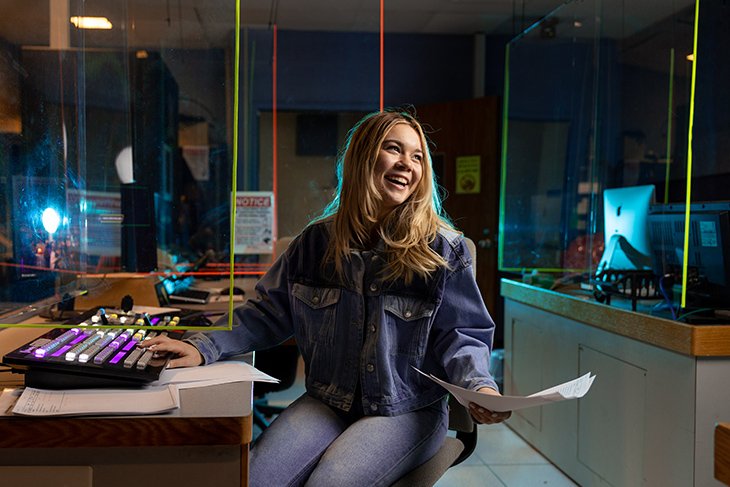 Emma Hug, a producer for News Central, poses by the video board in the television control room.