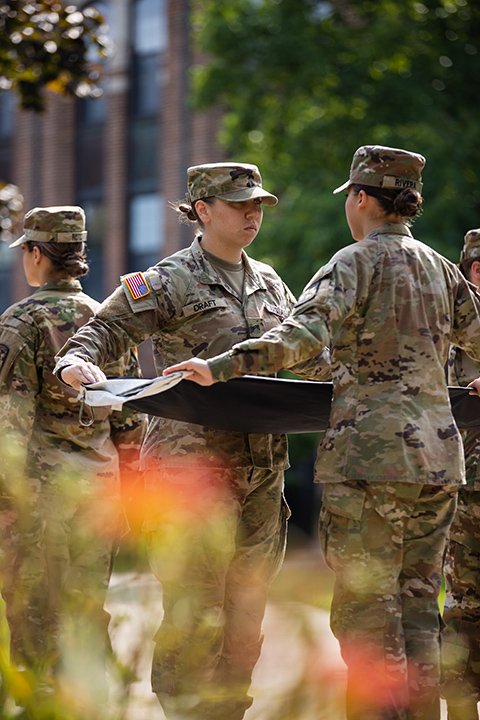 Members of the CMU ROTC program fold a flag.