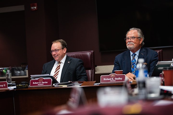 CMU President Bob Davies smiles while sitting next to board chair Rich Studley.