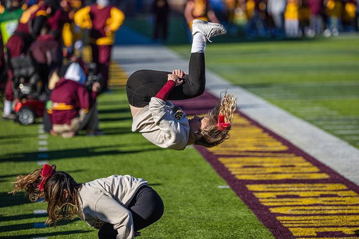 A cheerleader completes a flip during the CMU homecoming football game.