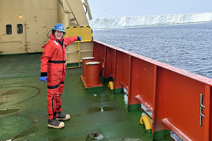 A Central Michigan University doctoral student aboard a research ship points to a glacier in the Southern Ocean.