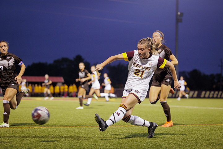 Women's soccer player Claudia Muessig takes a shot during a night game against Western Michigan University.