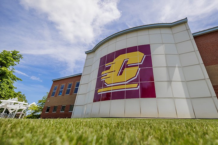 A large CMU logo on the side of a white brick building.
