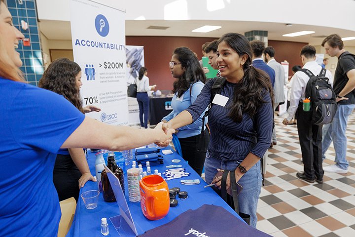 A CMU student shakes hands with an employer during a STEM job and internship fair.