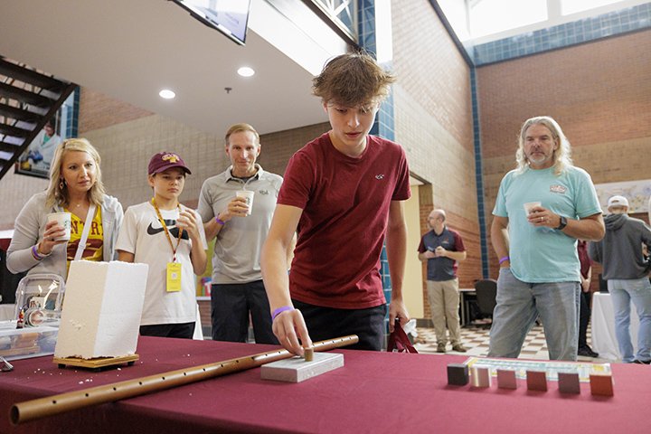 A prospective CMU student tries a game on a table inside the Engineering and Technology Building during CMU & You Day.