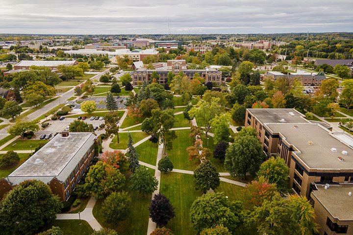 An aerial view of CMU's campus on an early fall day. Trees are beginning to change color from green to orange, yellow and red.