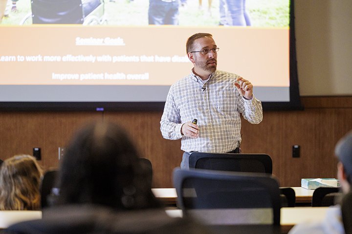 Shay Dawson gives a presentation in front of a group of medical students in a large room.