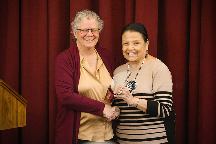 Susan Grettenberger hands an award to Suzanne Cross.