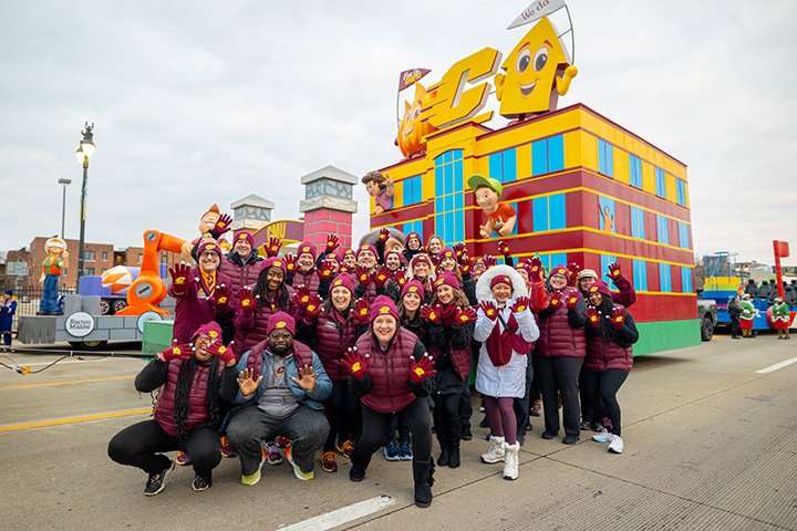 A group of CMU volunteers pose for a photo in front of the CMU Thanksgiving parade float.