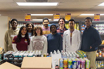 Nine CMU students pose for a photo in the student food pantry.