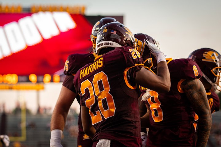 CMU football players celebrate in the end zone following a touchdown.