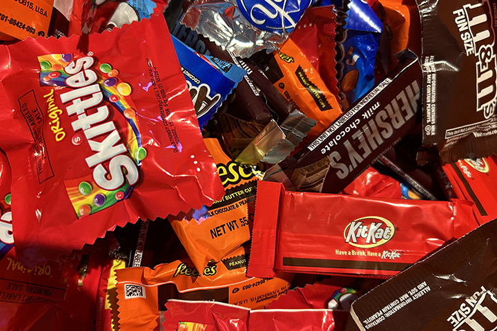 A pile of Halloween candy including bagged candies and candy bars.