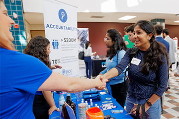 A student shaking hands with a potential employer.