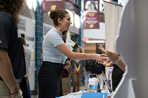 A woman shaking hands with other people at a career fair.