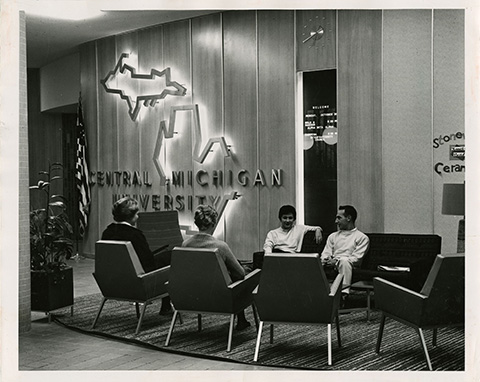 An undated black and white photo shows a group of CMU students sitting in the lounge area of the Keeler Union building – known today as the Bovee University Center.