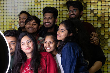 A group of young men and women pose for a photo in a selfie booth.