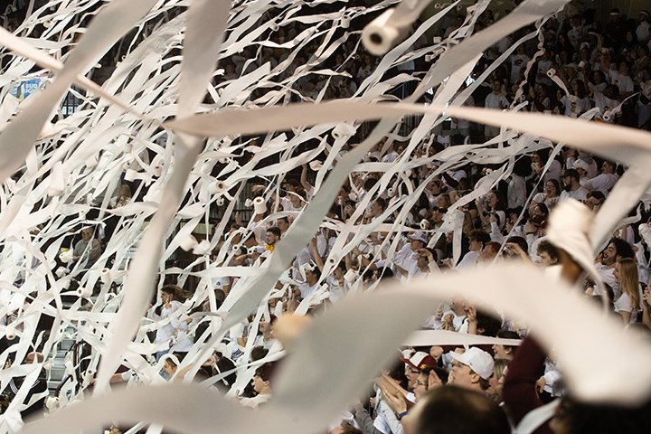 Hundreds of rolls of toilet paper fly through the air during a CMU basketball game, leaving a trail of paper streamers.